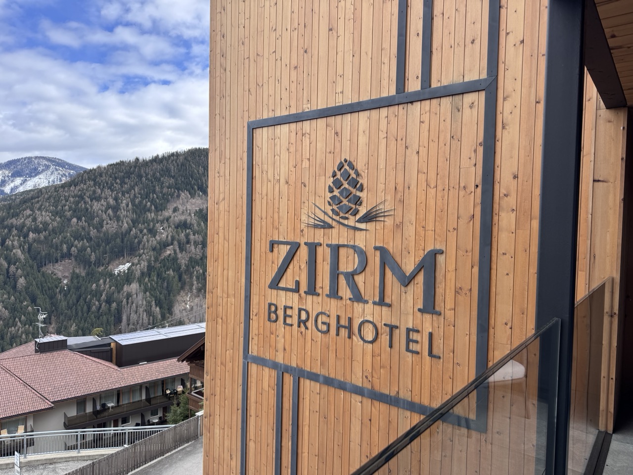 Skier leaving an alpine hotel terrace directly onto a groomed Kronplatz slope