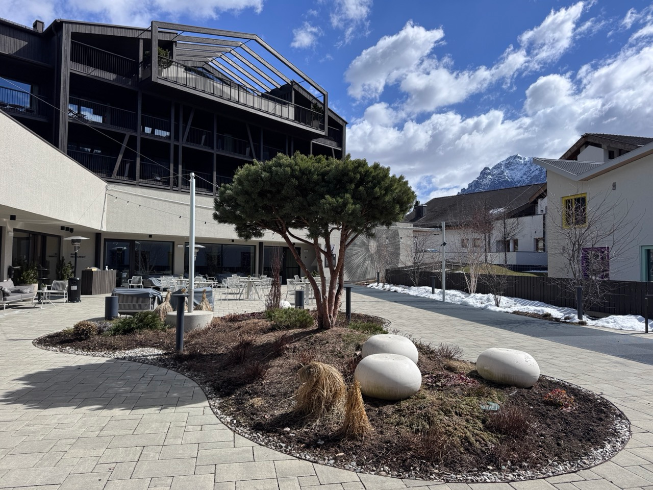 AMA Stay courtyard terrace with mountain views and spring snow in San Vigilio