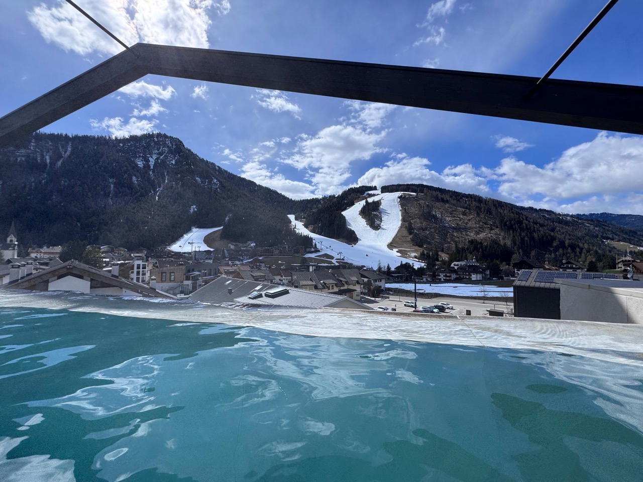 Rooftop pool at AMA Stay overlooking Kronplatz slopes and the village