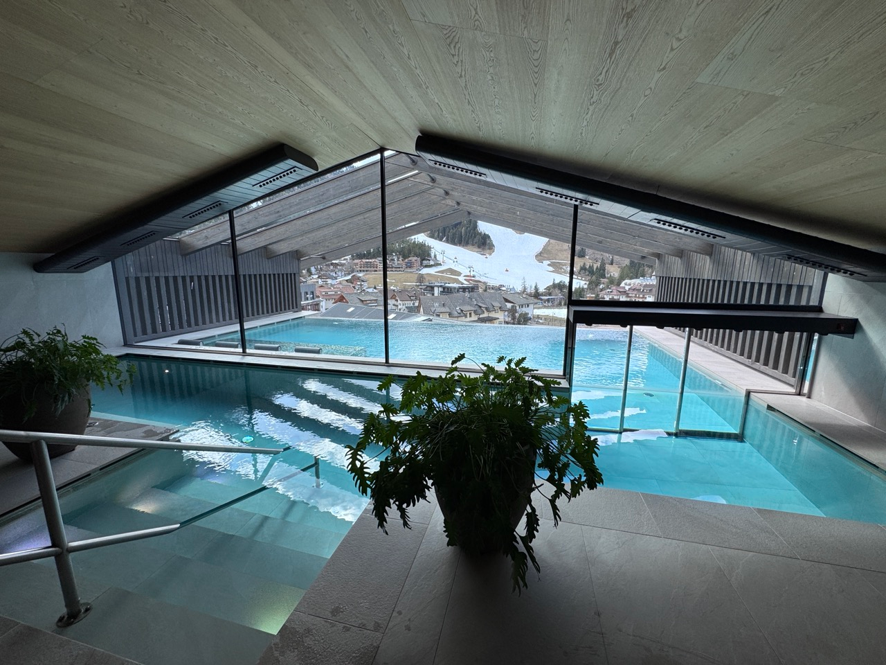 Indoor pool and spa area at AMA Stay with mountain views through glass