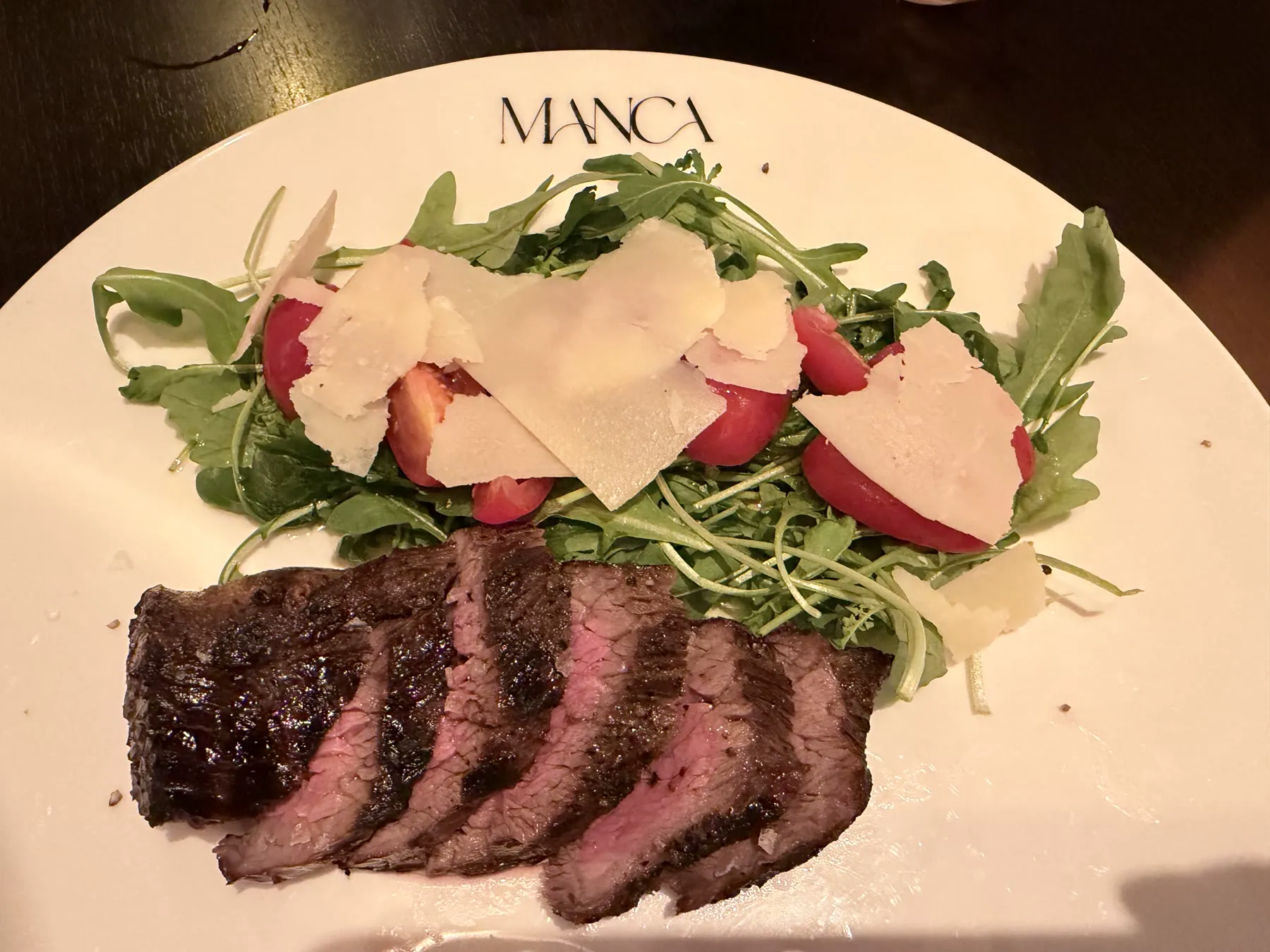 Tagliata di manzo at Manca Veldhoven with sliced bavette, rocket, tomato, and Parmesan